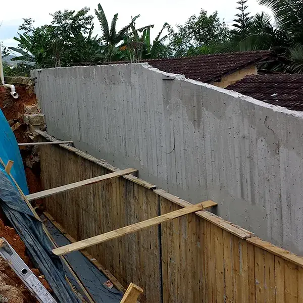 Muro desformado com manta geotêxtil e tubo dreno na face em contato com o solo